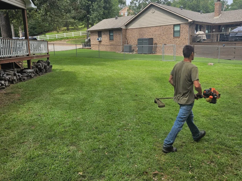 Worker on site holding a weedeater
