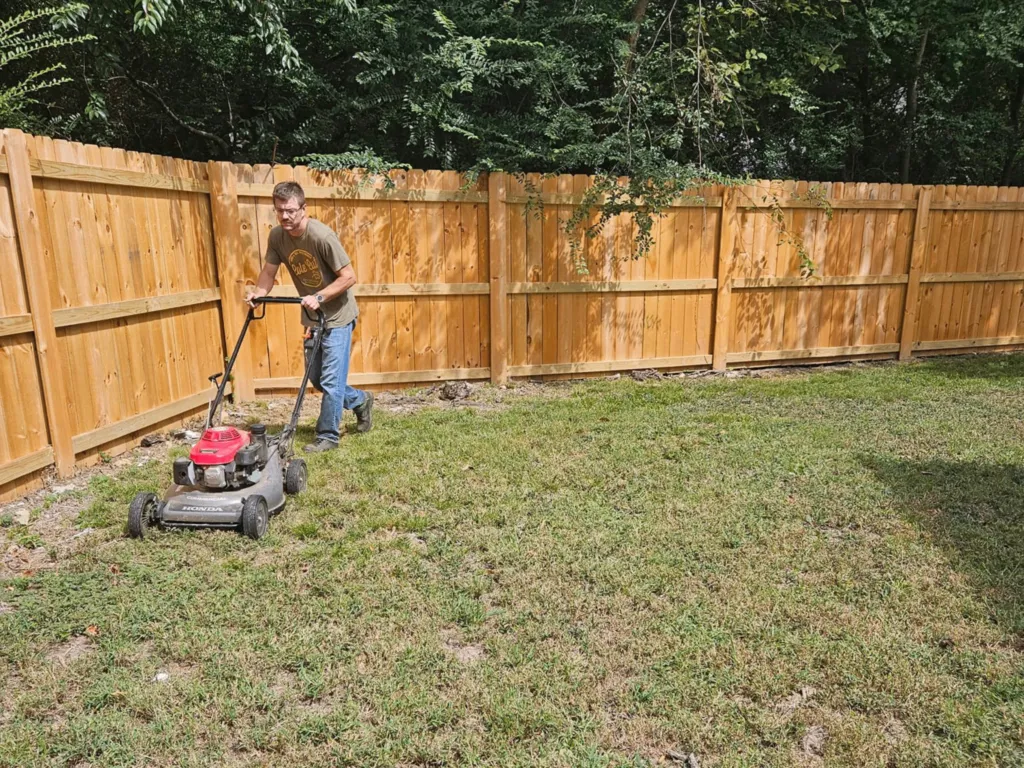 Worker on site pushing a lawn mower